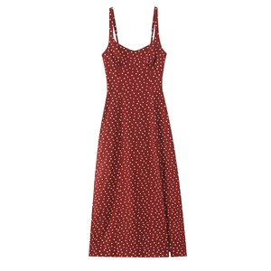 Detailed view of the side slit and classic polka dot pattern on the red midi dress