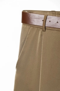 Macro detail of satin-textured wide leg trousers with premium leather belt and pleats