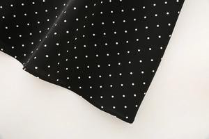 Detail of black and white polka dot fabric with fine rolled hem and draped texture