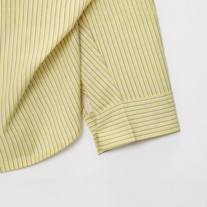 Detailed view of yellow and white striped poplin shirt with high-quality cuff stitching