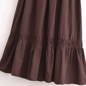 Brown halter dress featuring tiered hem and ruffled fabric texture details