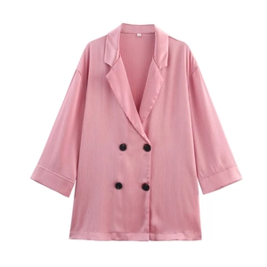 Detail of pink double-breasted blazer showing textured chiffon fabric and black buttons