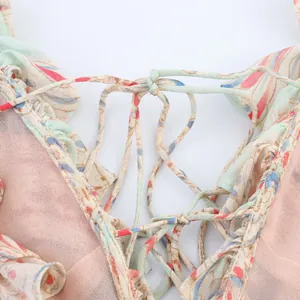 Détail d'une robe fleurie avec laçage croisé au dos sur fond blanc immaculé
