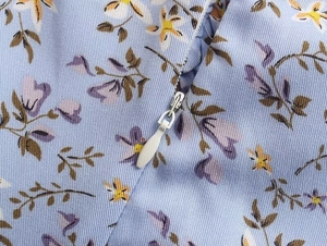 Détail d'une fermeture éclair invisible et tissu en sergé à fleurs pour robe d'été