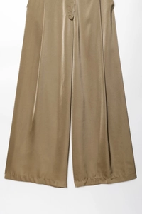 Detailed texture of high-waist bronze satin wide-leg pants with metallic silk luster