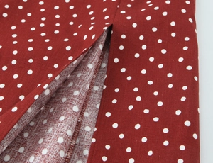 Detail of red and white polka dot dress fabric showing high-quality split hem stitching