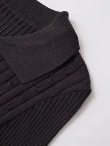 Detail of dark grey knit top showing collar and intricate cable stitch patterns