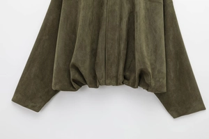 Detail view of olive green suede bomber jacket showing textured hem and sleeve cuffs