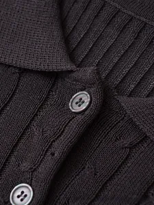 Detail of dark brown knit polo with cable stitch pattern and textured buttons