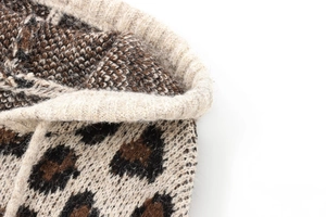 Macro shot of knitted leopard print jacquard fabric with detailed rolled edge texture