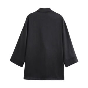 Detail shot of black oversized blazer featuring vertical ribbed knit texture and loose fit