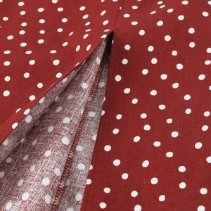 Close-up of red polka dot midi dress showing split hem and overlock stitching details