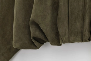 Detailed macro shot of olive green flight jacket hem with soft brushed suede texture