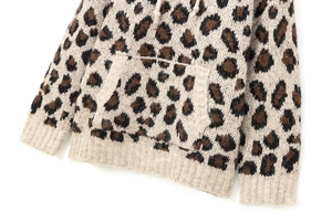 Detail of leopard print knit hoodie showing kangaroo pocket and ribbed sleeve texture