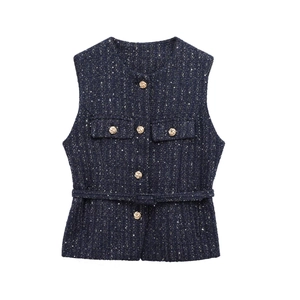 Close-up of navy tweed vest featuring gold buttons and sparkling metallic fabric texture