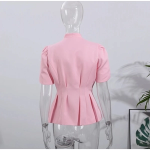 Détail du blazer rose à manches courtes avec taille plissée et basques évasées