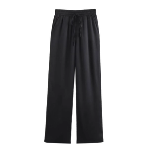 Detail of black wide-leg pants with vertical ribbed texture and elastic drawstring waist