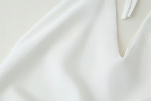 Gros plan détaillé sur la texture du tissu tissé blanc d'une robe dos nu chic