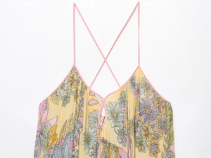 Detail of yellow floral dress showing V-neckline with teardrop cutout and pink straps