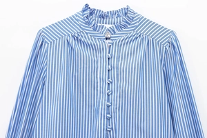Detailed close-up of blue and white striped shirt with ruffled collar and fabric buttons