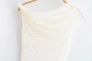 Close-up of elegant white lace fabric texture and detailed ruffles on one-shoulder top