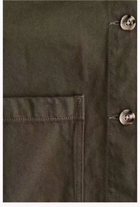 Macro shot of twill cotton utility jacket with tortoise shell buttons and stitching