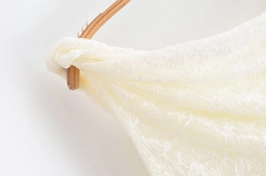 Close-up of off-white lace fabric with intricate floral crochet and mesh details