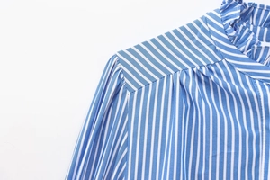 Detail of ruffled collar and puffed shoulders on a blue striped cotton blouse