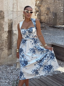Detail of blue floral print midi dress with sweetheart neckline and white slim belt
