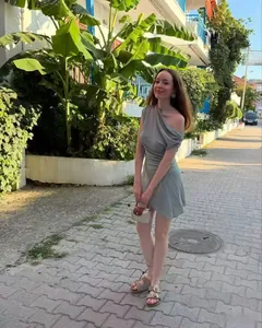Détail d'une robe courte asymétrique vert grisâtre avec des plis latéraux élégants