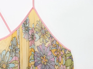 Macro shot of yellow floral dress with pink straps and vertical pleat texture