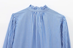 Detail of ruffle neck and pleats on a blue and white striped cotton blouse for women