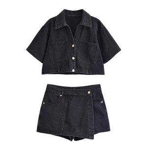 Detail of black washed denim set featuring cropped shirt and asymmetrical skort