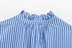 Close-up of ruffled stand collar detail on a blue and white striped cotton shirt