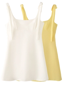 Detail of adjustable bow-tie shoulder straps on white and yellow gingham mini dresses