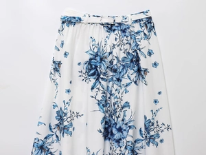 Detailed view of the pleated white floral high-waist midi skirt with matching belt