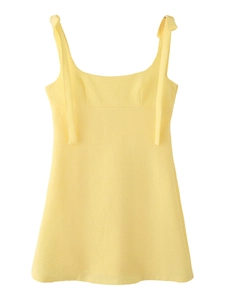 Detail of yellow gingham summer dress featuring dainty shoulder bow ties and square neckline