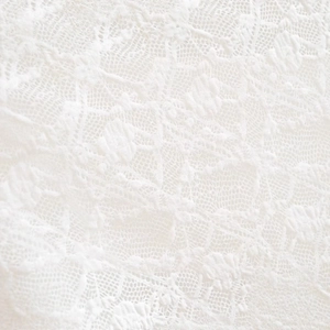 White lace top featuring intricate floral embroidery and delicate hollow-out fabric texture