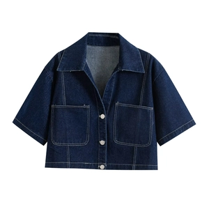 Detailed view of dark blue denim jacket with white contrast stitching and utility pockets