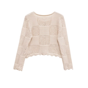 Détail d'un pull beige en maille ajourée à damier avec des bordures festonnées
