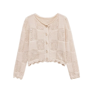 Détail du pull en maille crochetée avec motifs géométriques et bords ondulés élégants