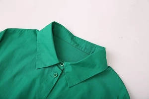 Detailed macro view of the emerald green shirt collar with matching buttons and neat stitching