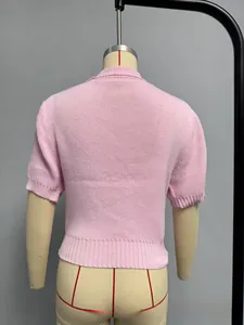 Detail view of pink knit short sleeve top showing the back texture and ribbed hem
