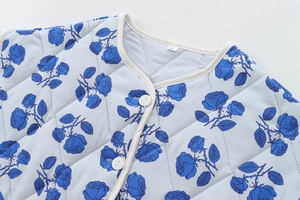 Close-up of diamond-quilted light blue cotton jacket with blue rose floral pattern and buttons