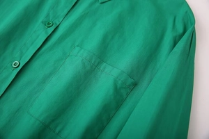 Detail of emerald green cotton shirt showing square pocket and matching resin buttons