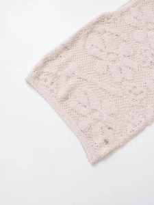 Détail de la texture d'un tricot beige clair montrant le fil bouclé doux et de haute qualité