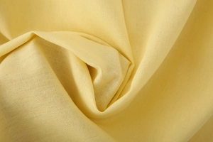 Macro shot of the soft pale yellow linen blend fabric with uniform cross-weave texture
