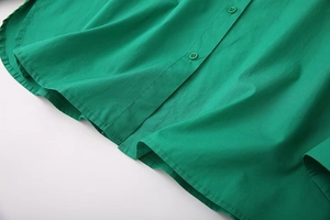 Detail of green cotton shirt showing curved hem and matching resin buttons