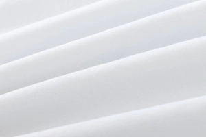 Close-up of premium white cotton fabric showing soft pleated texture and fine weave