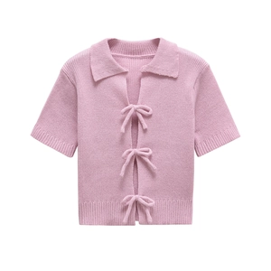 Pink short sleeve knit cardigan with bow ties and ribbed texture on white background
